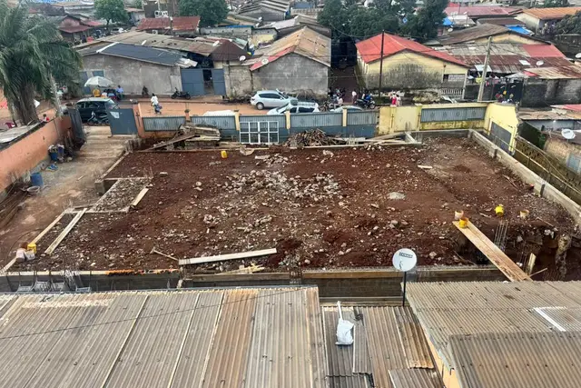 Vue aérienne du site de l’église après la démolition de l’ancien temple, terrain dégagé entouré de la clôture
