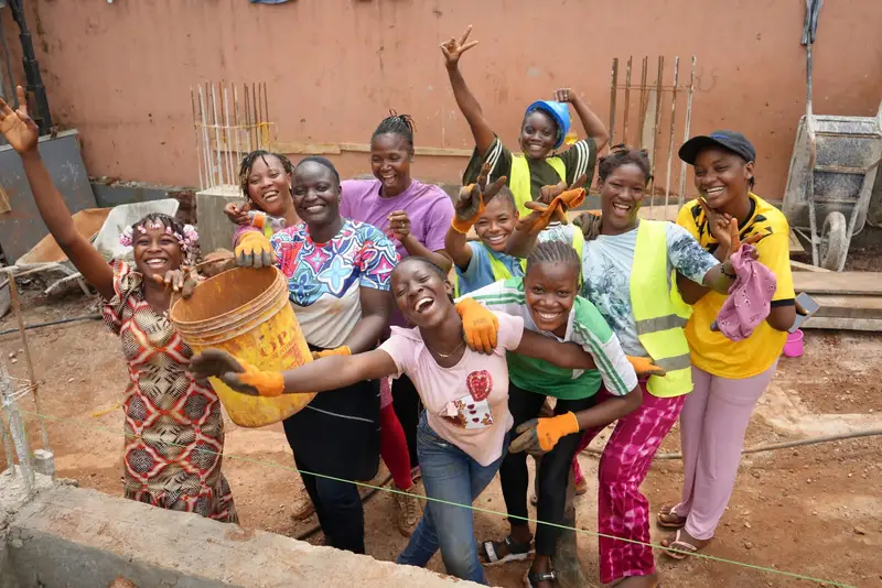 Groupe de femmes de l’église, gants aux mains, souriantes sur le chantier